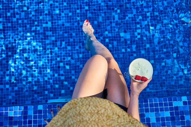 žena u bazénu s koktejlem